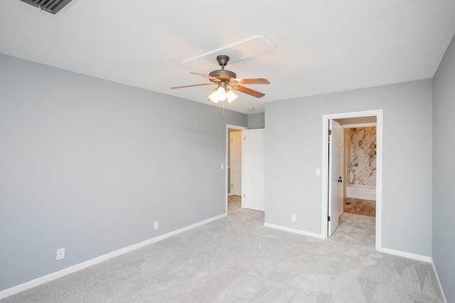 unfurnished bedroom featuring ceiling fan, light carpet, and connected bathroom