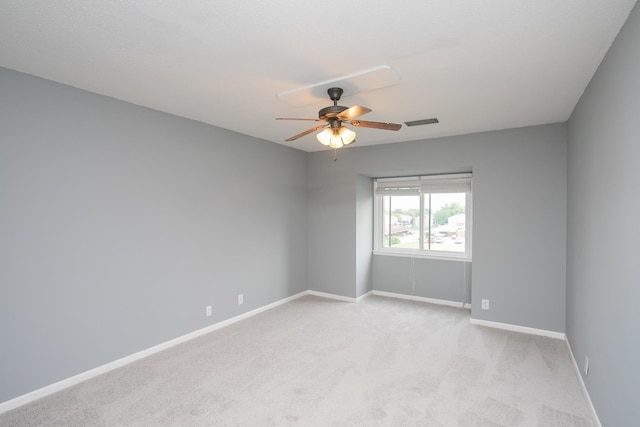 carpeted spare room featuring ceiling fan