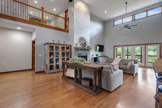 living room with ceiling fan, a healthy amount of sunlight, a fireplace, and light wood-type flooring