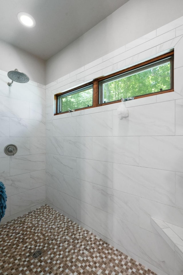 bathroom featuring plenty of natural light and tiled shower