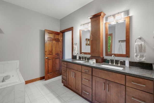 bathroom with tile patterned flooring, vanity, and tiled bath