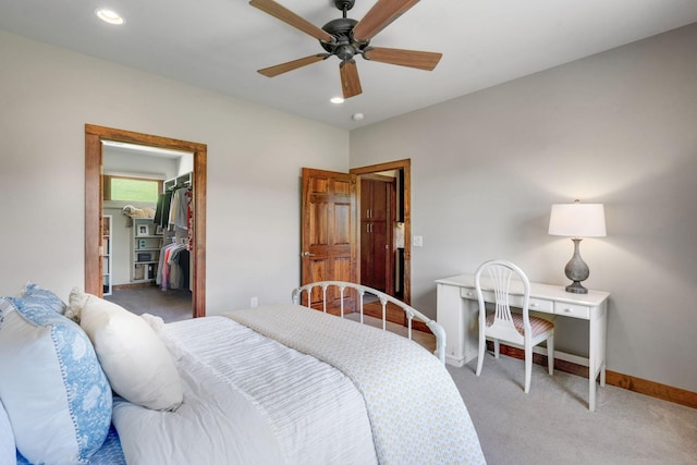 carpeted bedroom with ceiling fan, a closet, and a spacious closet