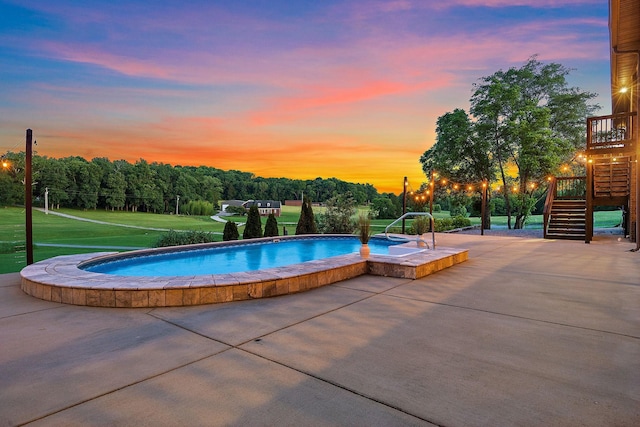 pool at dusk featuring a yard and a patio area