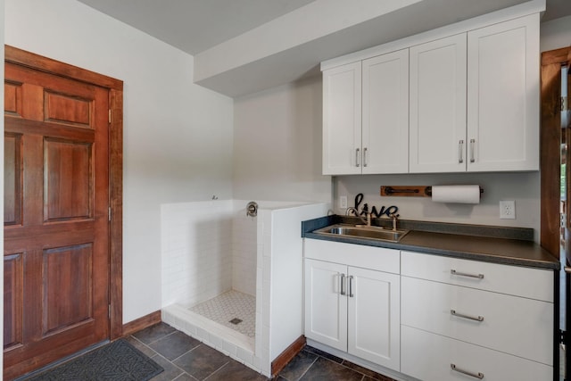 interior space with a tile shower, vanity, and tile patterned floors