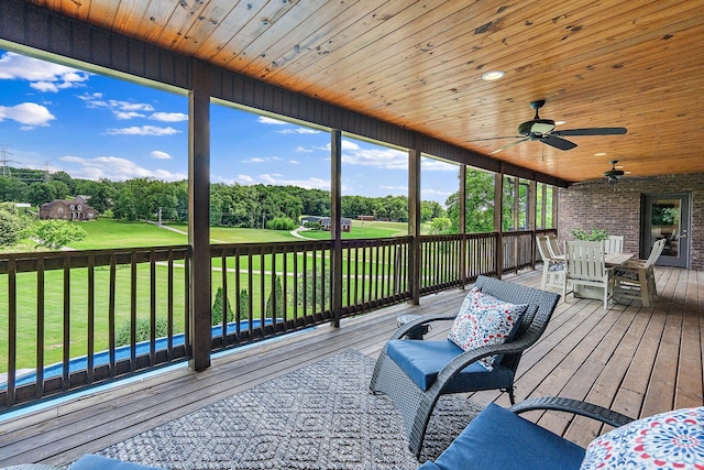 wooden deck with ceiling fan and a lawn