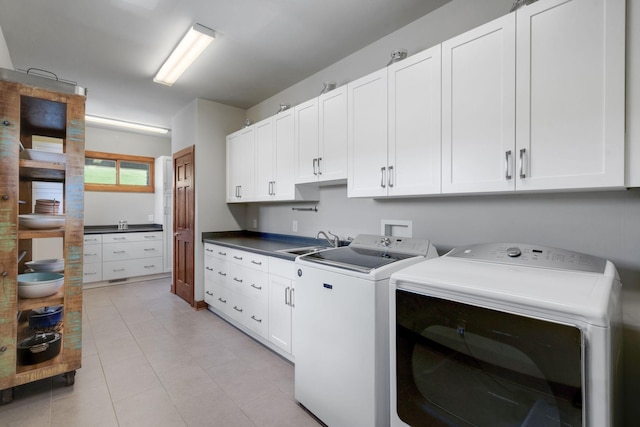 laundry room with light tile patterned flooring, cabinets, sink, and washer and dryer