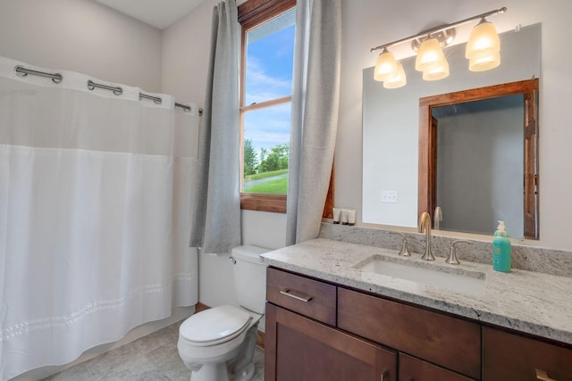 bathroom with a wealth of natural light, vanity, and toilet