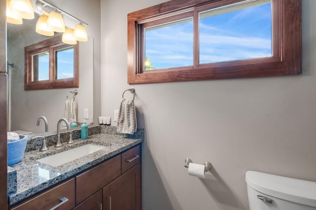 bathroom with a wealth of natural light, vanity, and toilet