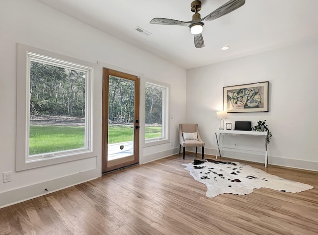 living area with ceiling fan and light wood-type flooring