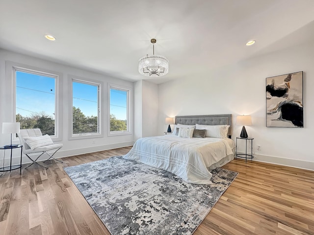 bedroom with light hardwood / wood-style flooring and a chandelier