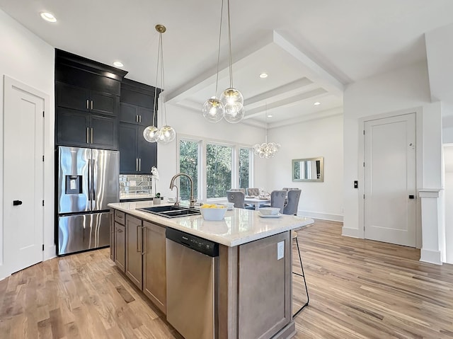 kitchen with sink, beamed ceiling, decorative light fixtures, a center island with sink, and appliances with stainless steel finishes