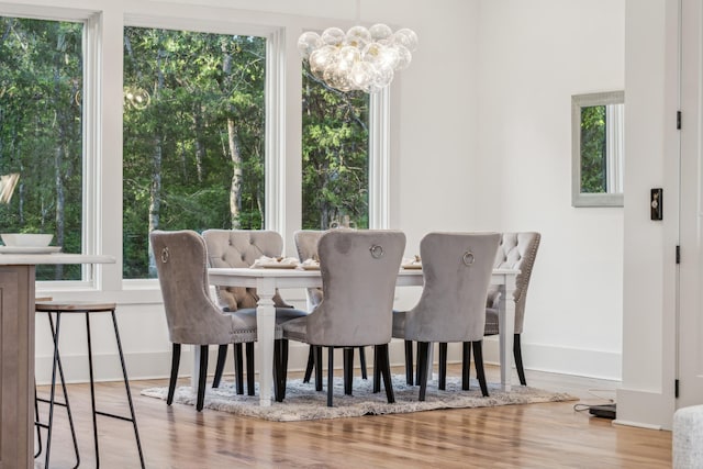 dining area with light wood-type flooring and a chandelier