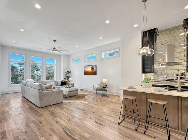 living room with light wood-type flooring and ceiling fan