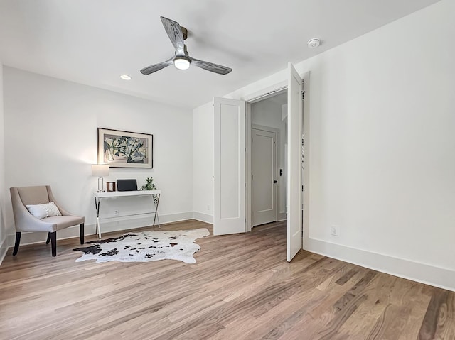 living area with light hardwood / wood-style floors and ceiling fan