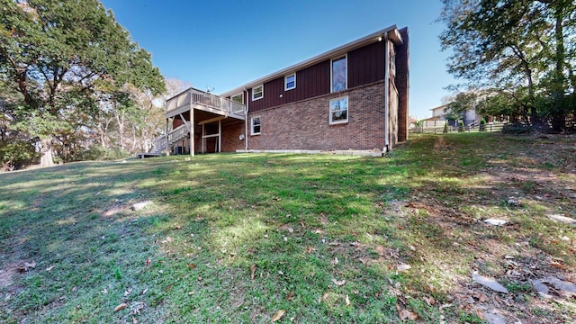 rear view of house with a lawn and a deck