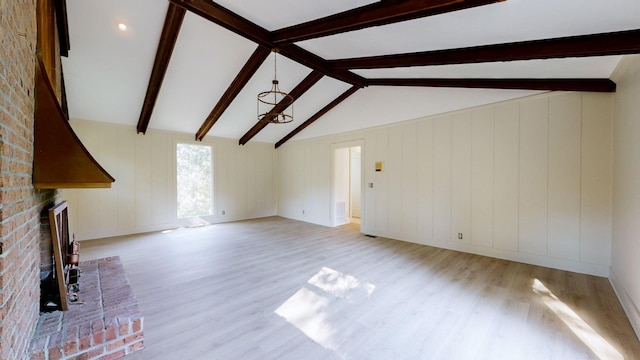 unfurnished living room with vaulted ceiling with beams, light hardwood / wood-style flooring, and a fireplace