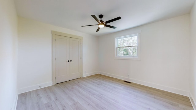 unfurnished bedroom with ceiling fan, a closet, and light hardwood / wood-style flooring