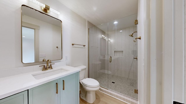 bathroom featuring walk in shower, hardwood / wood-style floors, vanity, and toilet