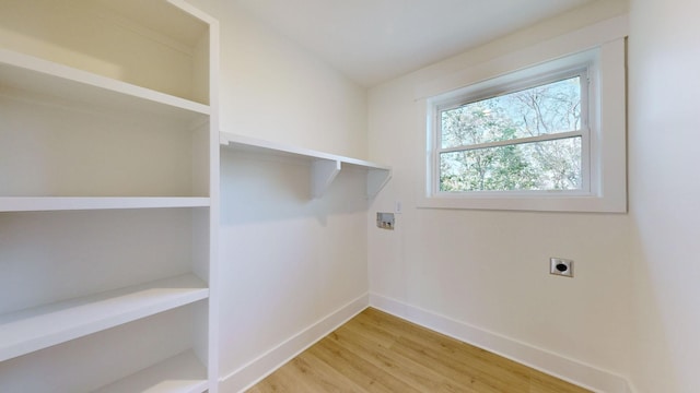 laundry area featuring hookup for an electric dryer and light hardwood / wood-style flooring