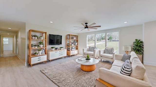 living room with ceiling fan and light hardwood / wood-style flooring