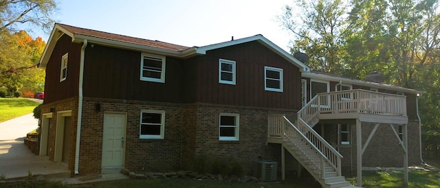 back of property with central AC, a garage, and a deck