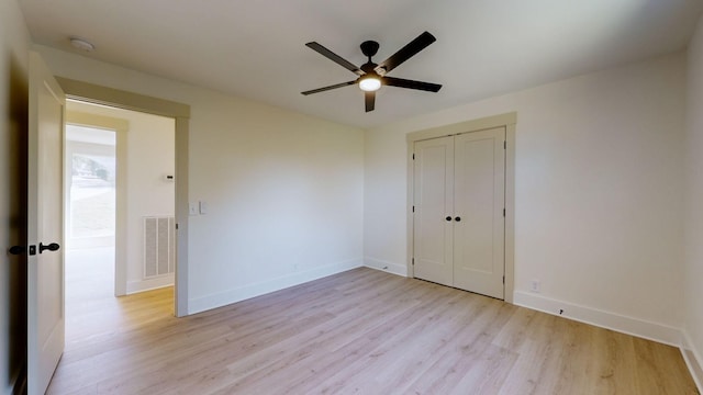 unfurnished bedroom with ceiling fan, light hardwood / wood-style flooring, and a closet