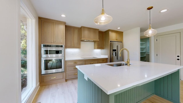 kitchen with pendant lighting, a spacious island, sink, appliances with stainless steel finishes, and a healthy amount of sunlight