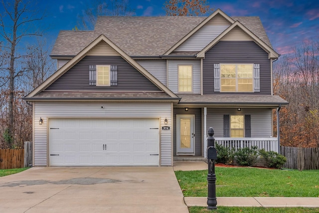 view of front of house with a lawn, a garage, and covered porch