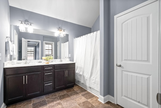 bathroom featuring vanity and lofted ceiling