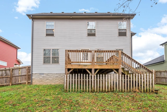 rear view of house featuring a wooden deck and a yard