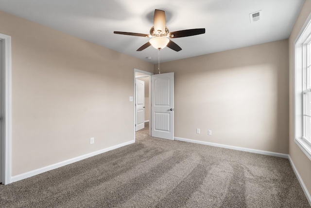 carpeted empty room featuring ceiling fan and a healthy amount of sunlight