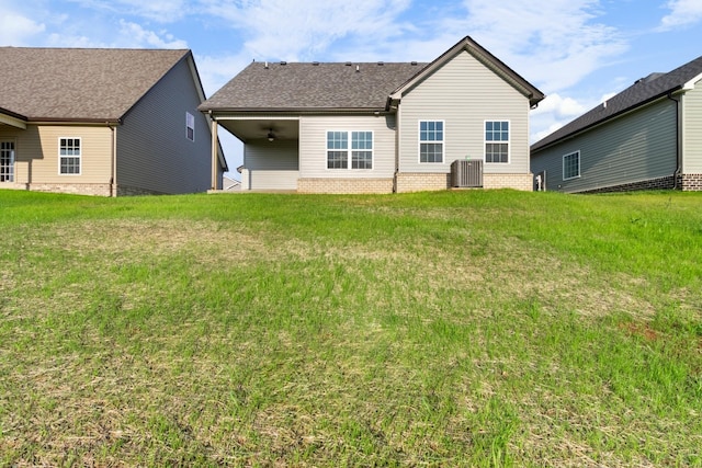 rear view of property with central AC unit, ceiling fan, and a lawn