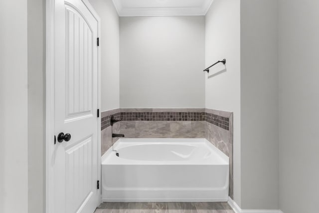 bathroom with a tub to relax in and ornamental molding