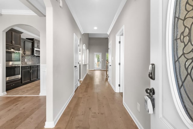 hallway featuring crown molding and light hardwood / wood-style floors