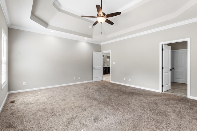 unfurnished bedroom with a raised ceiling, ceiling fan, carpet flooring, and crown molding