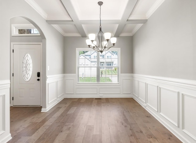 entryway featuring a chandelier, beam ceiling, light wood-type flooring, and coffered ceiling