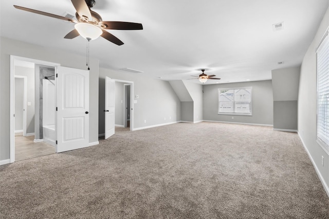 additional living space with ceiling fan and light colored carpet