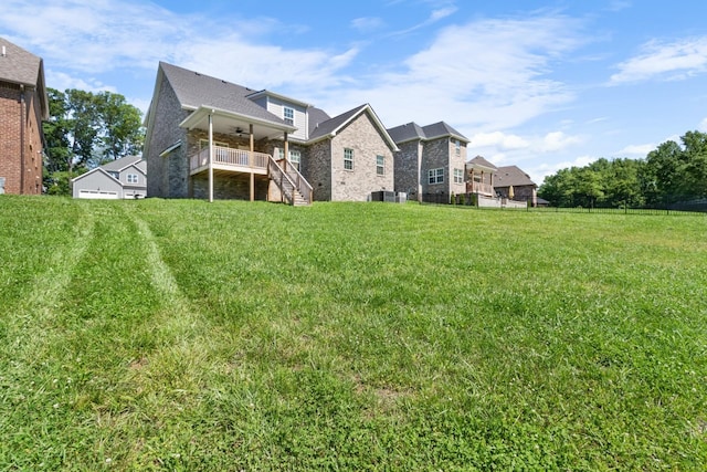 back of property with central air condition unit, ceiling fan, and a yard