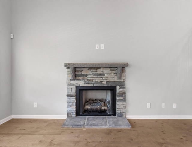 room details featuring hardwood / wood-style floors and a stone fireplace