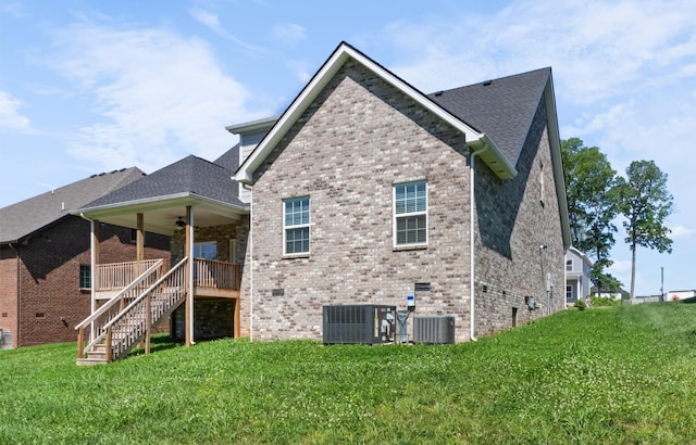 back of house featuring a wooden deck, ceiling fan, a yard, and cooling unit