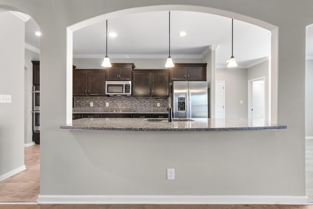 kitchen with stone counters, hanging light fixtures, and appliances with stainless steel finishes