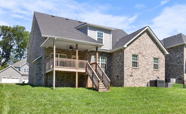 rear view of property featuring central air condition unit, a wooden deck, ceiling fan, and a yard