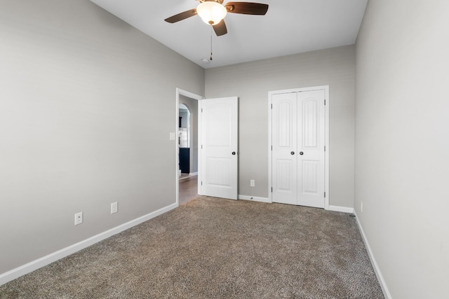 unfurnished bedroom with carpet floors, a closet, and ceiling fan