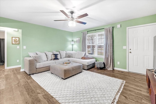 living room featuring ceiling fan and hardwood / wood-style floors