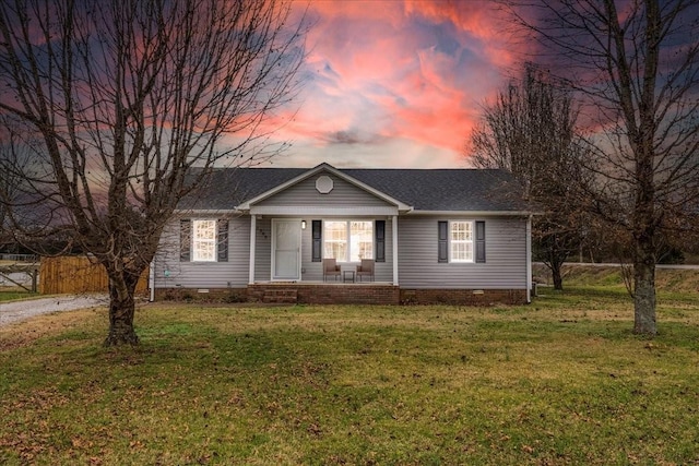 ranch-style home featuring a porch and a lawn