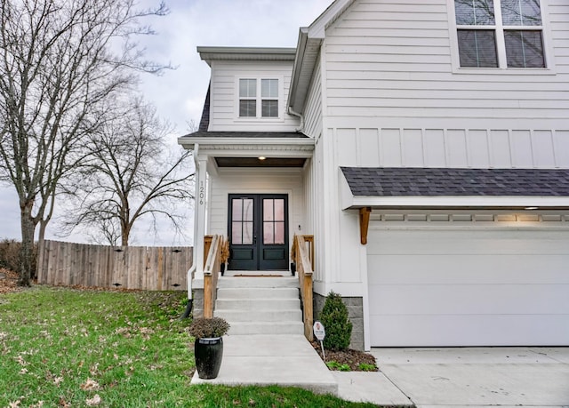 view of front facade with a garage, a front yard, and french doors