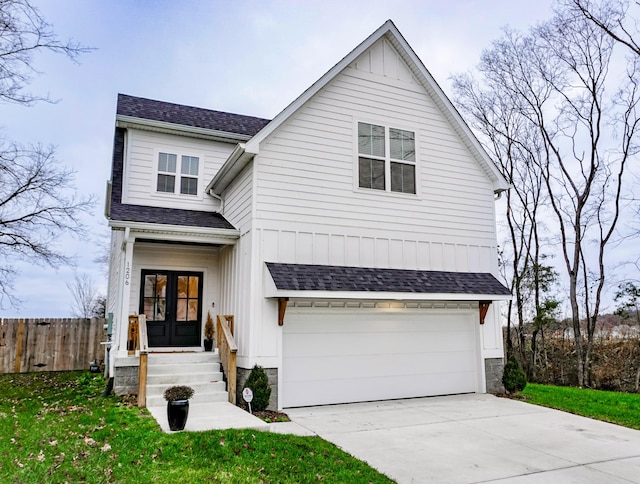 view of front of house featuring french doors, a garage, and a front lawn