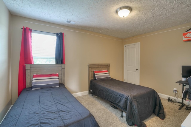 carpeted bedroom featuring a textured ceiling