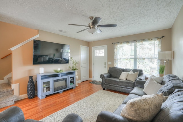 living room with ceiling fan, hardwood / wood-style floors, and a textured ceiling