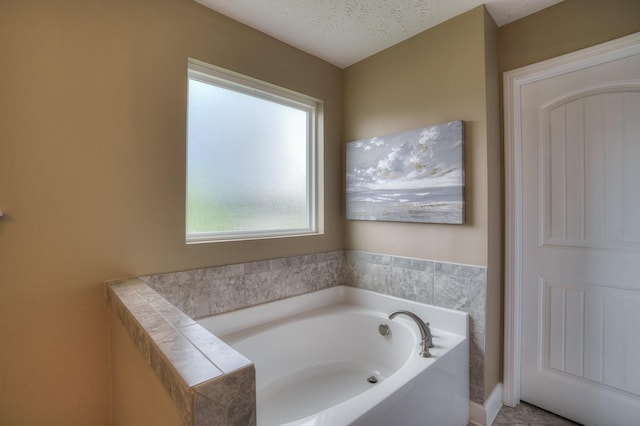 bathroom featuring a textured ceiling and a bath